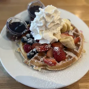 a waffle topped with whipped cream and fruit