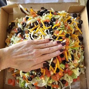 Put my hand in the picture just to show scale this is an entire pizza box filled with nachos.