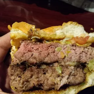 a hand holding a hamburger
