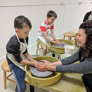 The boys getting a lesson on how to use the potters wheel and brushing on the glaze after their bowls we're finished.