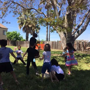 Welcoming the heat with water balloon play. School age group.