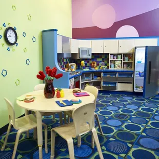 Because playing house never goes out of style, this home away from home features a miniature kitchen and washer-dryer combo.