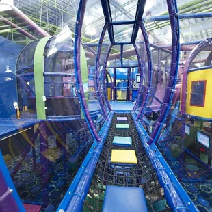 The Quest is a spectacular, multi-storied, indoor play piece consisting of tunnels, tubes, slides, and various physical challenges for kids.