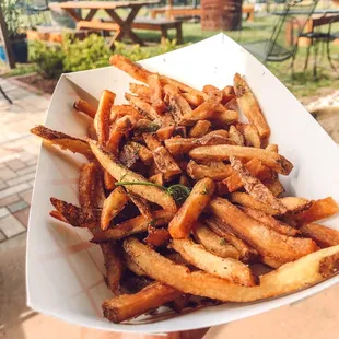a person holding a plate of fries
