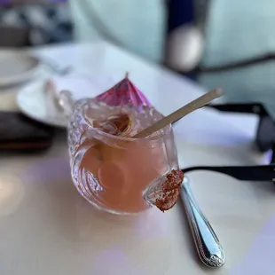 a pink drink with a spoon