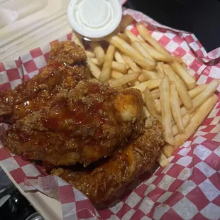 Chicken tenders dipped with sweet spicy sauce and fries