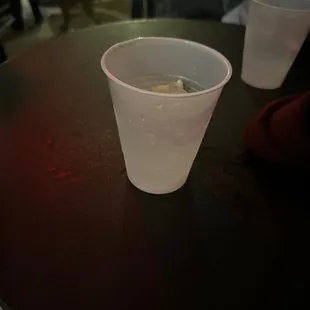 a plastic cup with a lemon in it
