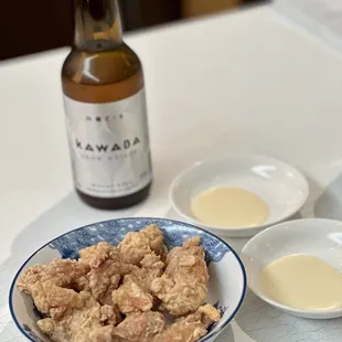 a bowl of fried chicken and a bottle of beer