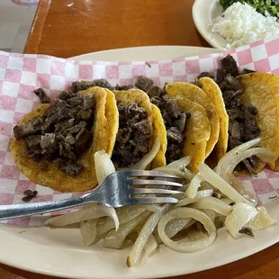 a plate of tacos with onions