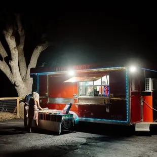 a woman sitting in a chair in front of a food truck
