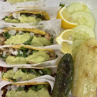 a variety of tacos on a paper plate