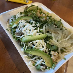 a salad with avocados and shredded cheese