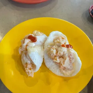 two pieces of sushi on a yellow plate