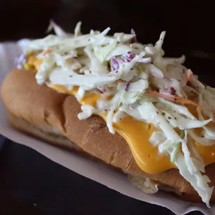 Cheese sauce and coleslaw on a hot dog