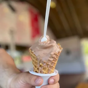 a hand holding an ice cream cone
