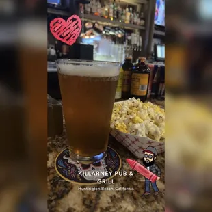 a glass of beer and popcorn
