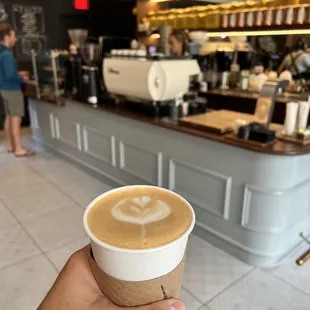 a hand holding a cup of coffee