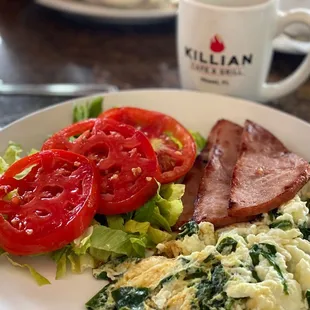 Egg whites with spinach, a side of ham with a tomato salad.