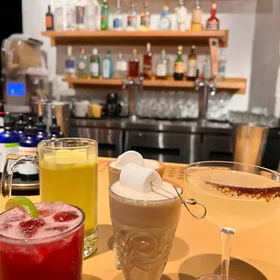 a variety of cocktails on a bar