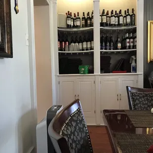 a dining room with wine bottles on the shelves