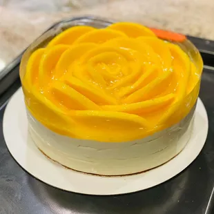 a yellow rose on top of a cake