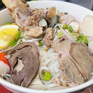 a bowl of noodles with meat and vegetables
