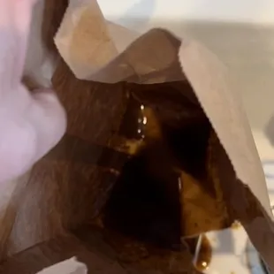 Paper bag with bottom filled with sauce