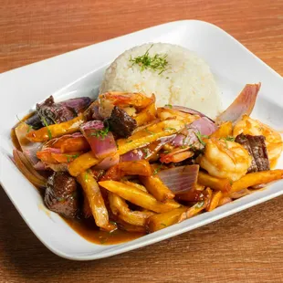Lomo Mar y Tierra- Beef and Shrimp sautéed with fries, tomato, onion, cilantro with a side of white rice.