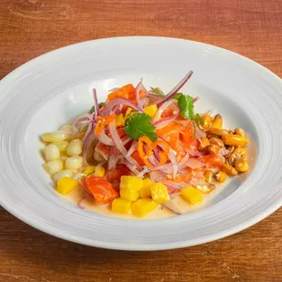 Ceviche de Salmon- Salmon marinated in fresh lime juice, onions, cilantro, mango chunks, and Peruvian pepper.