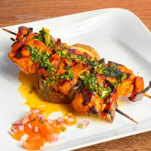 Anticuchos de Pollo- Chicken, bell peppers, and onion skewers with grilled potato slices, Peruvian corn, Salsa Criolla, and Peruvian aji.