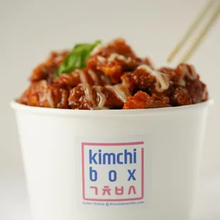 a bowl of kimchi with chopsticks