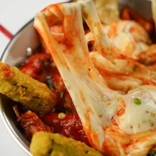 a person dipping a piece of kimchi into a bowl of kimchi