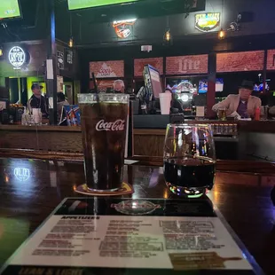 a drink and menu at a sports bar