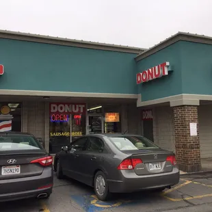 two cars parked in front of a donut shop
