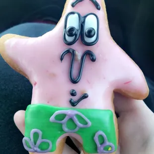 a hand holding a decorated cookie
