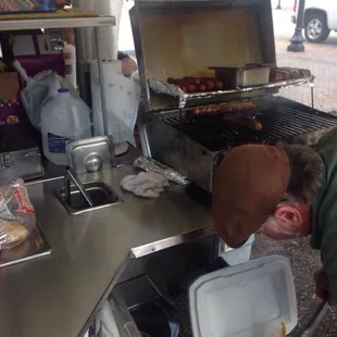 a man cooking hot dogs