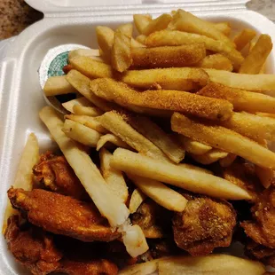 chicken wings and fries in a styrofoam container