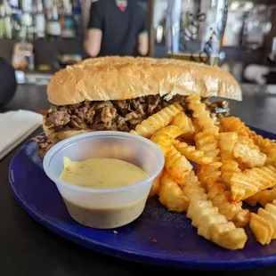 a sandwich and fries on a blue plate