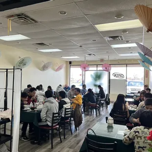 people sitting at tables with umbrellas hanging from the ceiling