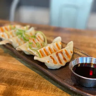 a plate of dumplings with dipping sauce