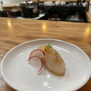 Seared scallop with lemon grass, miso dressing topped with lemon balm