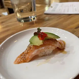 Seared salmon belly with honey wasabi mayo, topped with avocado, red tobiko and shiso