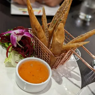 Pork eggrolls with sweet and sour sauce.