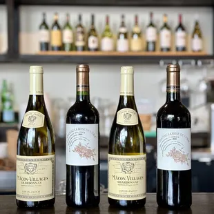 three bottles of wine lined up on a bar