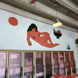 a naked woman on a wall in a restaurant