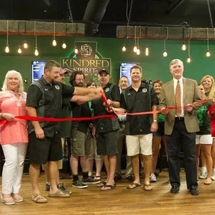 a group of people cutting a ribbon