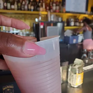 a hand holding a plastic cup