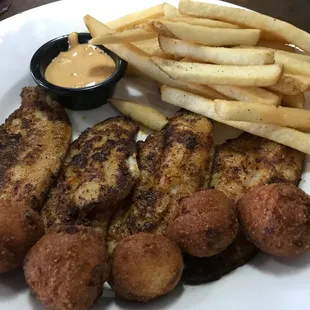 Mississippi Farm-Raised Catfish Dinner with hushpuppies, fries and marinated tomatoes.