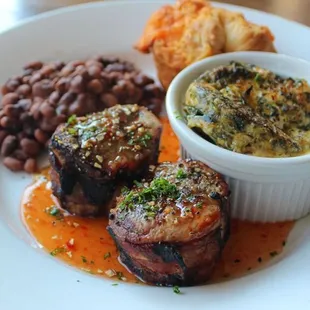 Pork Tenderloin Medallions wrapped in bacon shown here with black-eyed peas, spinach souffle and a pimento cheese roll.
