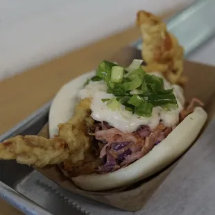 a bun with meat and vegetables in it